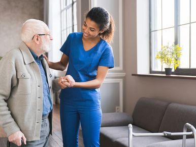 Portrait of an african young nurse helping old elderly disable man grandfather to walk