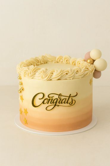 Elegant beige and peach gradient cake with gold "Congrats" topper and decorative balls.