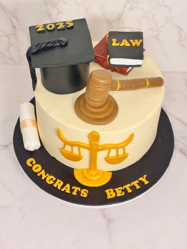 Graduation cake with law theme, gavel, and scales, congratulating Betty for 2025.