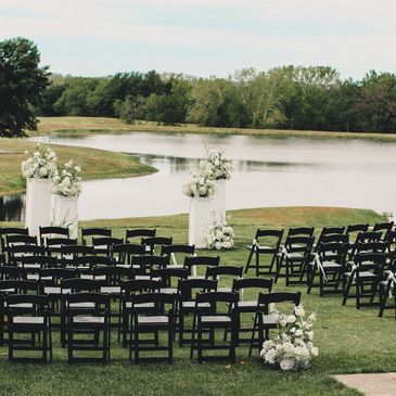 This is a wedding venue setup with chairs, alter and flowers overlooking the lake at Sandstone Count