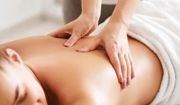 Person receiving a relaxing back massage with gentle hand pressure.