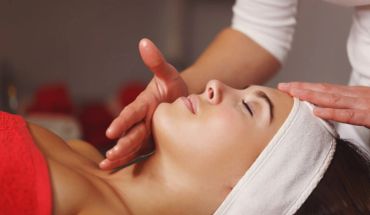 A woman receiving a soothing facial massage with a headband on.