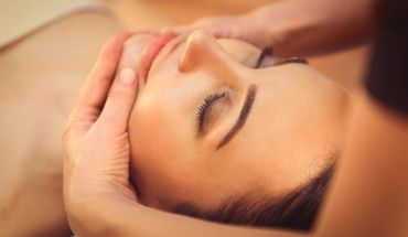 A person receiving a relaxing facial massage with eyes closed.