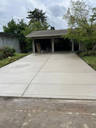 Newly poured concrete driveway leading to a double garage.