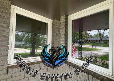 Two clean windows on a stone wall with outdoor reflections.