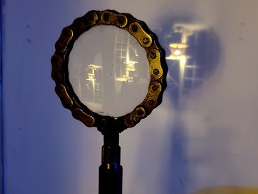 A bike chain linked in a circular shape on a stand.