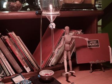 Wooden mannequin holding a sketchpad in an art studio.
