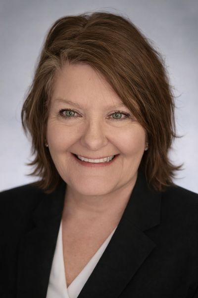 Professional woman with short brown hair smiling warmly.