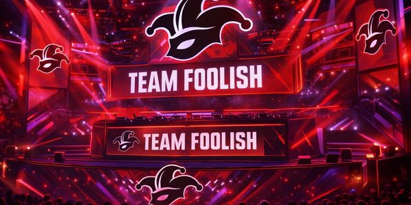Bright red stage with 'TEAM FOOLISH' and jester logos at an esports event.