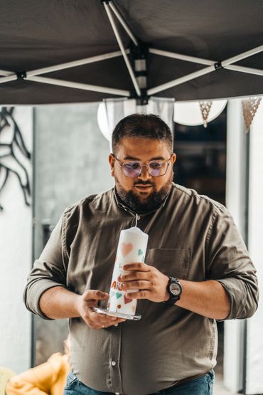 Vater hält stolz die Taufkerze während der Zeremonie