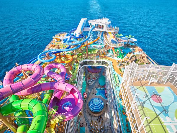 Colorful water slides and sports courts on a cruise ship deck.