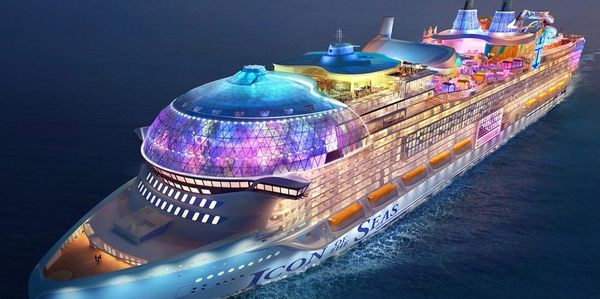 A large, colorful cruise ship at night.