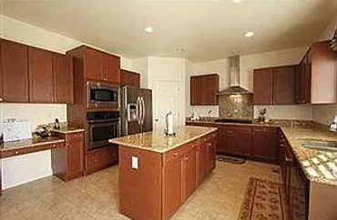 Spacious kitchen with wooden cabinets and central island.