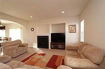 Cozy living room with beige sofas and a fireplace.