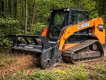 Orange Case 450 tracked machine clearing forest ground.