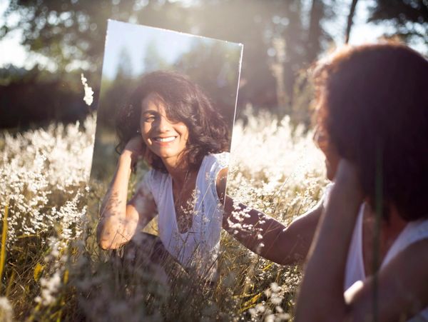 Smiling, Confident woman looking in mirror