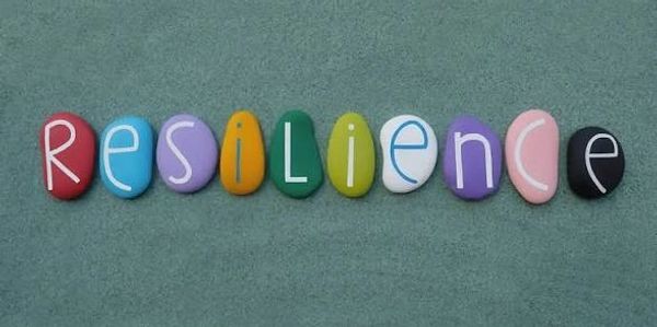 Colorful stones spell out the word 'resilience' on a textured background.