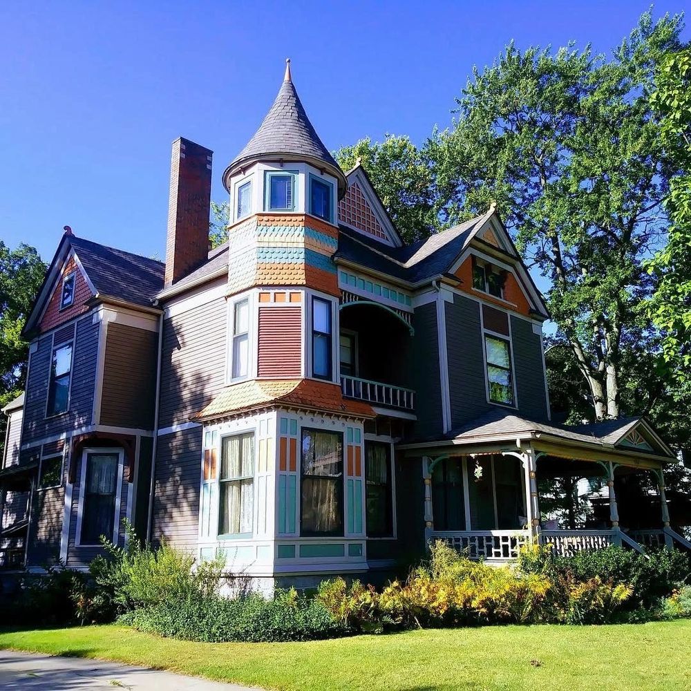 Historic home with three floors in a Queen Anne style on a sunny spring day.