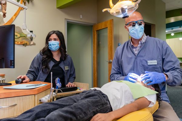 Certified pediatric dental specialists checking the patient