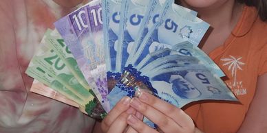Person holding various denominations of Canadian banknotes.