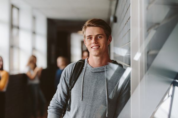 Happy high school male in gray sweatshirt smiling about SAT score increase. Walker Test Prep Review.