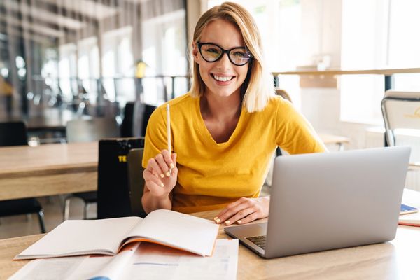 Blonde Girl Smiling at Desk Because She Increased her ACT English Score. Walker Prep Review.