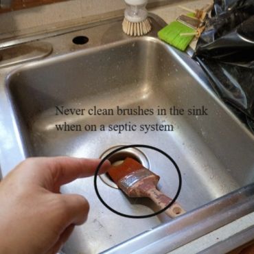 Someone cleaning a paint brush in a sink at a home on a septic system, this is never recommended, h