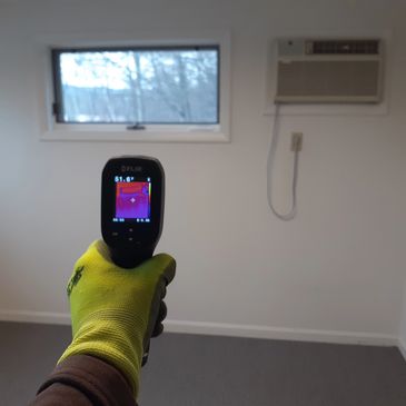 A building inspection contractor thermal imaging a wall at an annual building inspection.