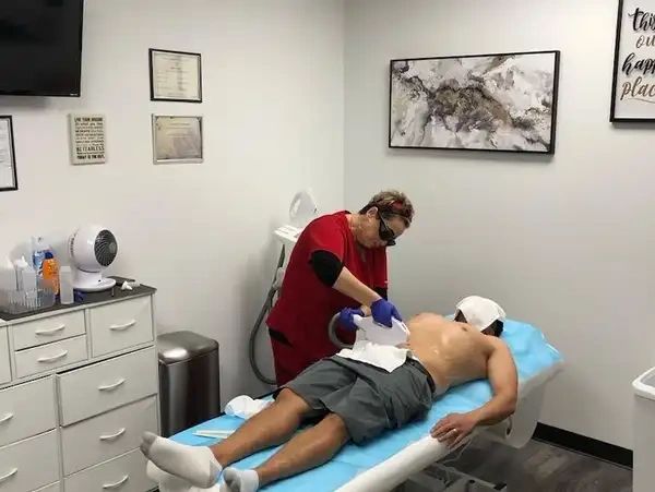 Man laying on bed getting laser hair removal