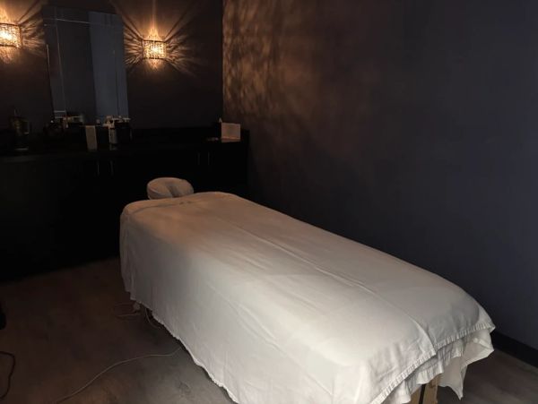 Cozy massage room with dim lighting and a massage table.