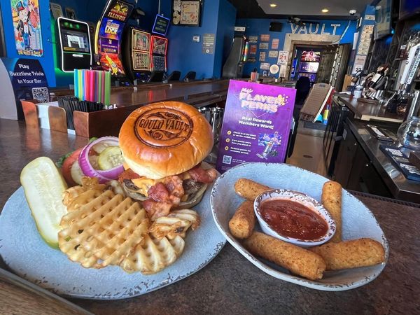 Bacon Cheeseburger with Waffle Fries. There is a side of Mozzarella Sticks with Marinara Sauce
