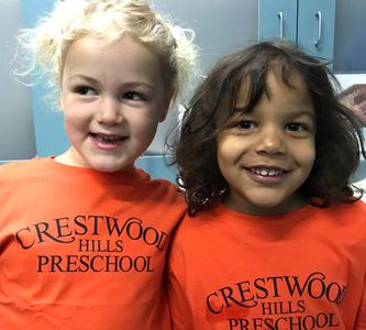 two kids wearing orange crestwood hills preschool shirts