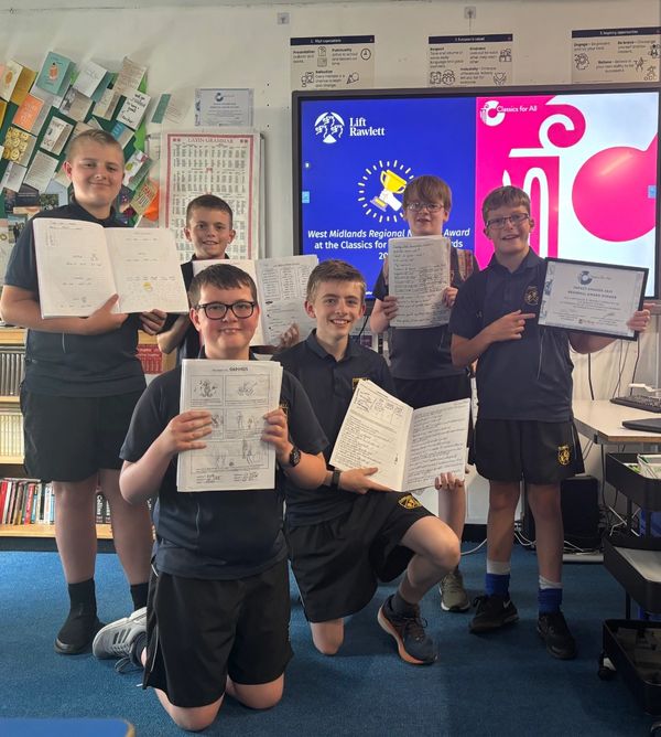 A group of six students proudly show their certificates and work in a classroom.