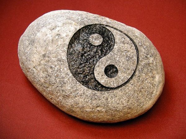 Engraved river rock garden stone with yin yang symbol.