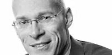 Black and white portrait of a man wearing glasses.