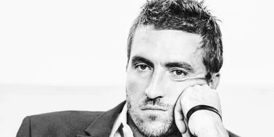 Man in contemplative pose resting his face on his hand.