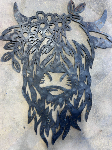 Metal art of a bearded bull with flowers on its head.