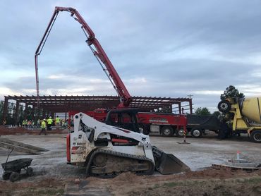 Construction site with heavy machinery and workers in high-visibility clothing.
