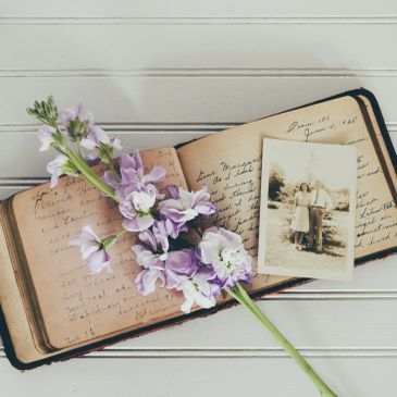 Vintage photo and handwritten journal with purple flowers.