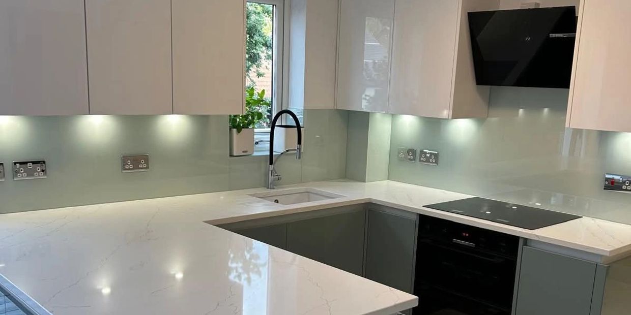 Modern kitchen with white countertops and under-cabinet lighting.