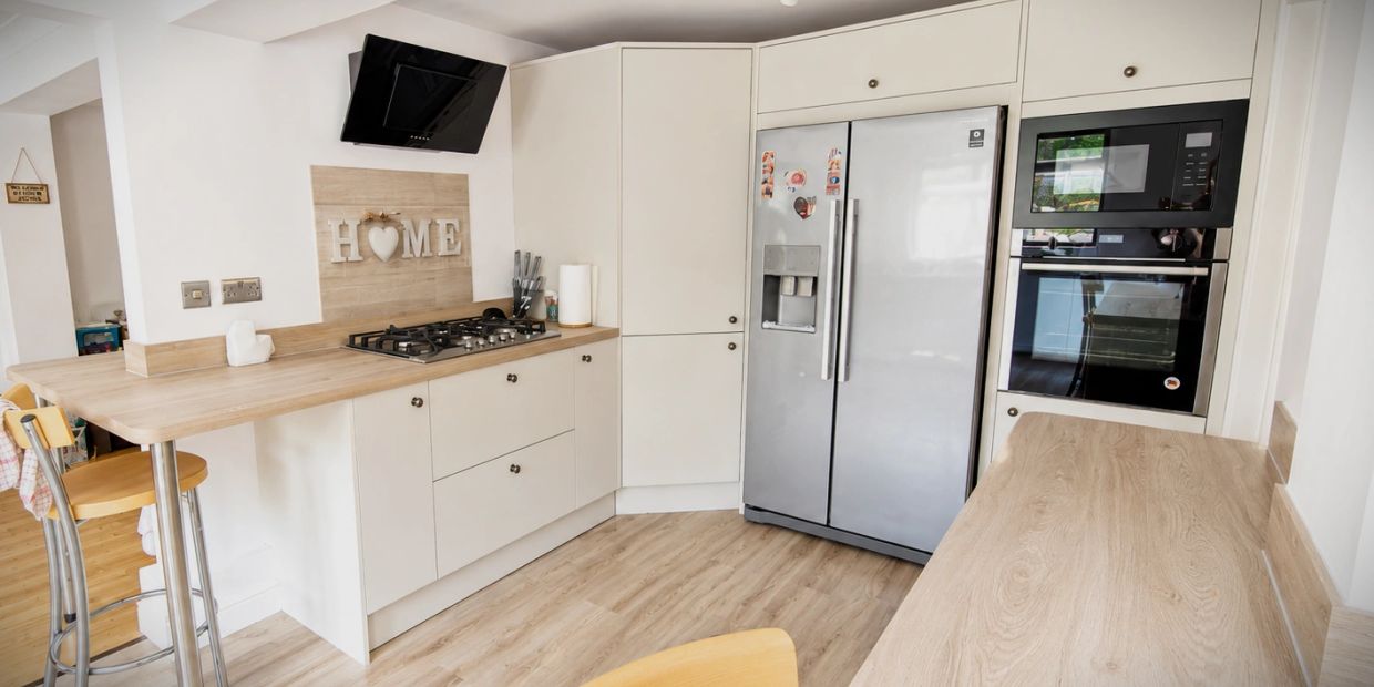 Modern kitchen with light wood counters and stainless steel appliances.
