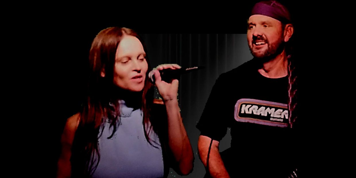 Man and woman singing on stage.