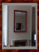 Red Framed Mirror on Brick Over Fireplace