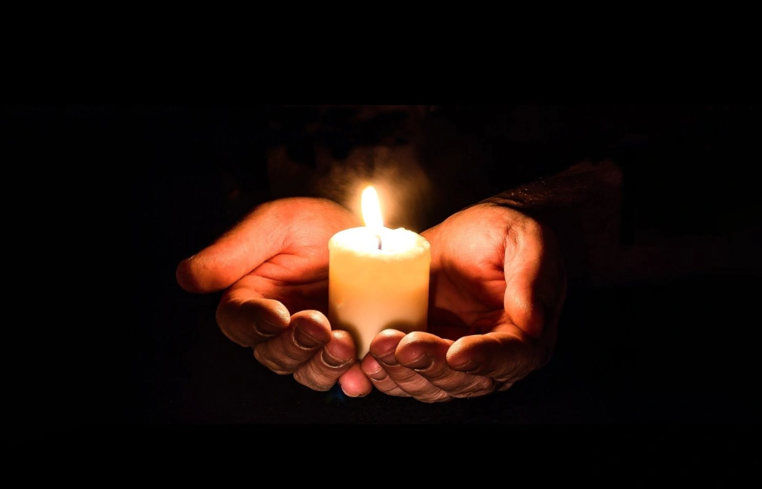 A person holding a candle in their hands