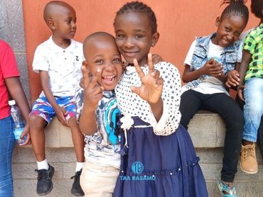 Happy children posing and smiling, showing peace signs.
