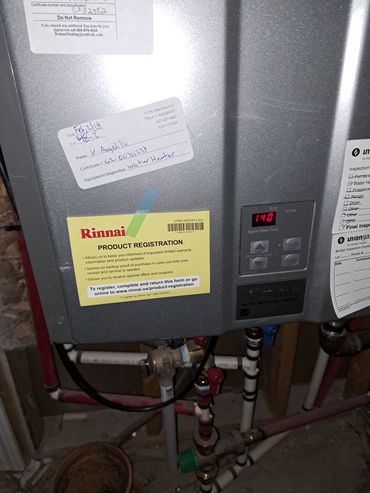 Rinnai water heater with inspection and registration labels.