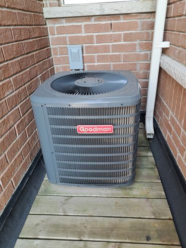 Goodman HVAC unit outside a brick house.