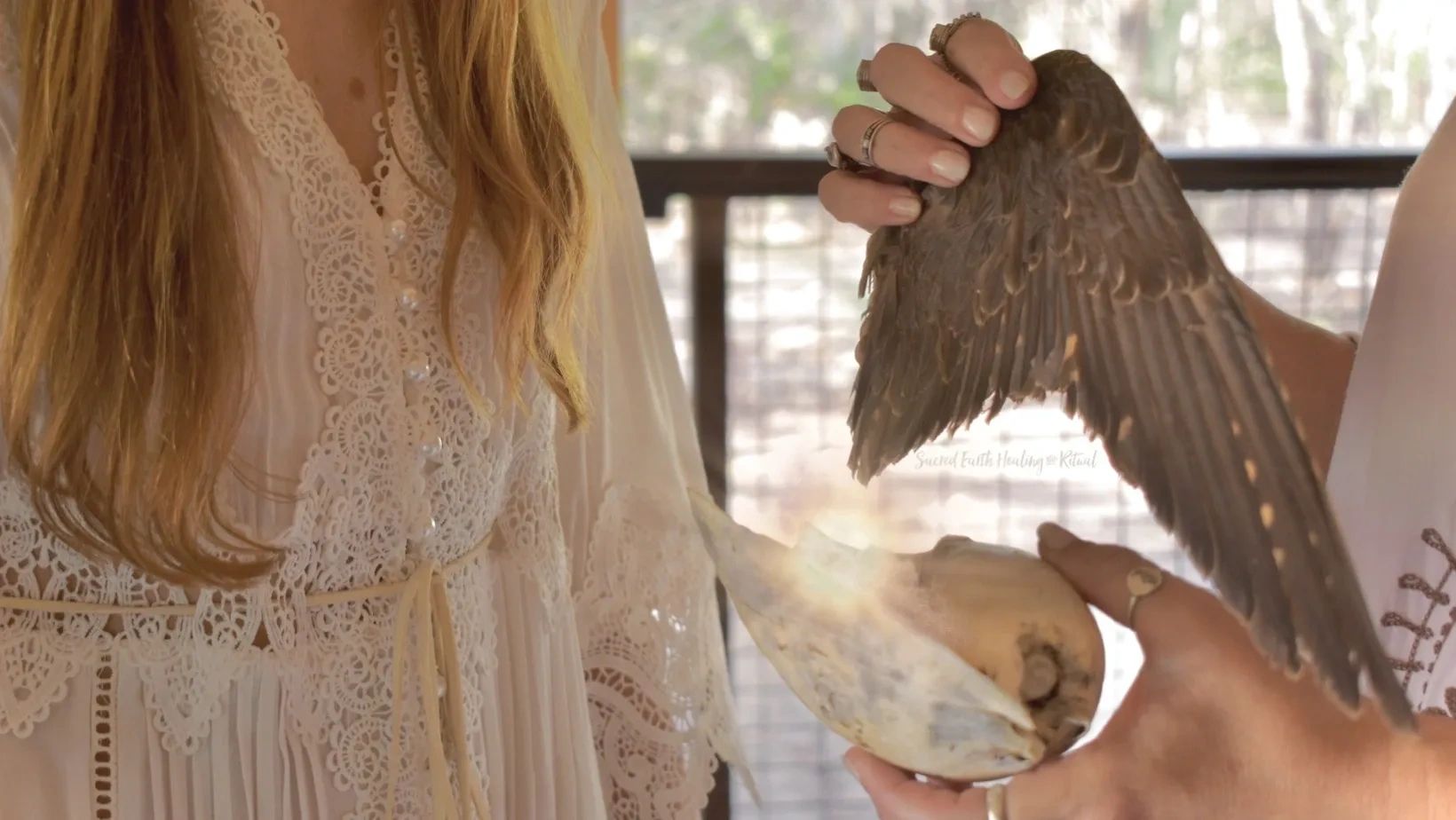 medicine woman with a wing and shell cleansing energies of another woman