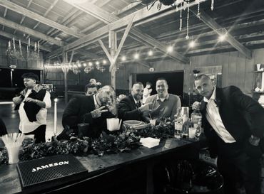 Group of people enjoying a rustic indoor party with drinks and casual vibes.