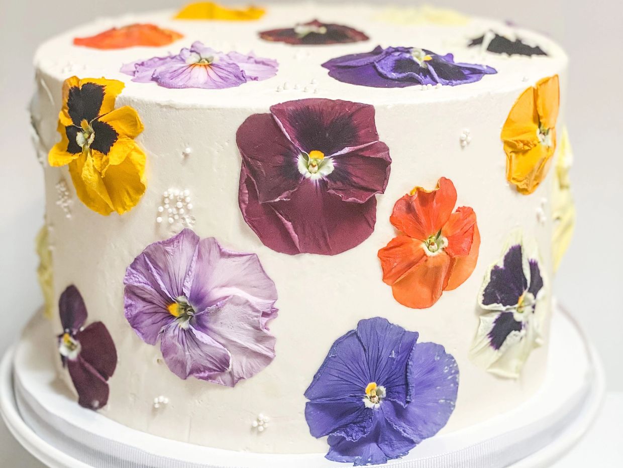 Decorative cake with colorful edible flowers.